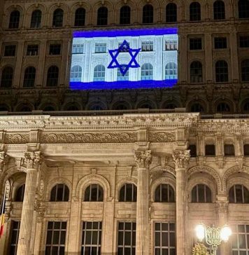Clădirea Palatului Parlamentului iluminată cu o proiecție a steagului israelian