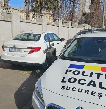 FOTO Un șofer și-a parcat mașina pe trotuar, cu o roată pe postamentul unei cruci. A intervenit Poliția Locală București