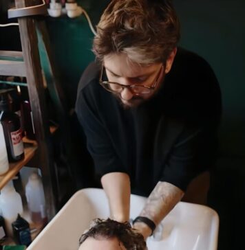 Nicuşor Dan se joacă cu o pisică, apoi se aşează pe scaunul frizerului unde este tuns şi spălat